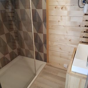 Douche moderne en bois dans un hébergement insolite à Champagne-Ardennes.