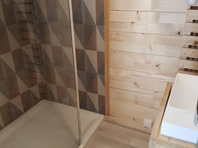 Douche moderne en bois dans un hébergement insolite à Champagne-Ardennes.