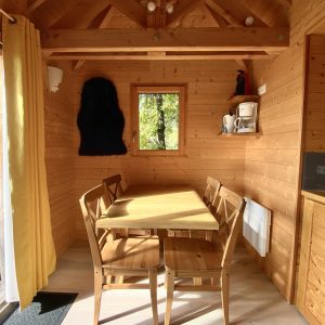 Cabane en bois chaleureuse avec une table en bois et des murs en lambris.