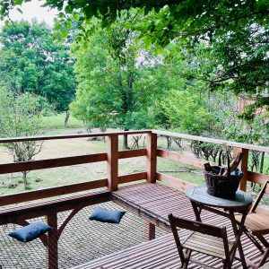 Cabane perchée en Auvergne-Rhône-Alpes avec terrasse en bois et vue sur la nature.