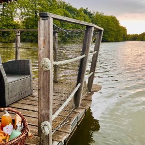 Cabane flottante en Auvergne-Rhône-Alpes, avec vue sur le lac et mobilier en bois.