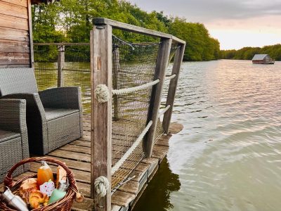 Cabane flottante en Auvergne-Rhône-Alpes, avec vue sur le lac et mobilier en bois.