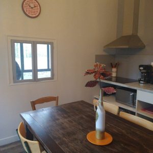 Hébergement insolite en Champagne-Ardenne, cuisine moderne avec table en bois et décor chaleureux.