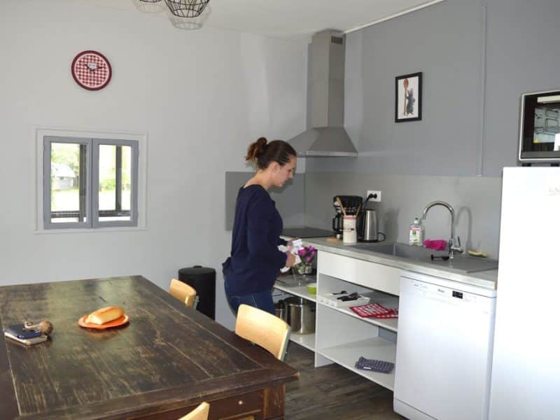 Hébergement insolite à Champagne-Ardenne : cuisine moderne avec table en bois et décor chaleureux.