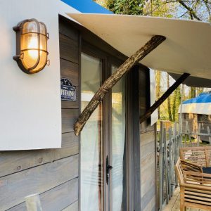 Hébergement insolite en bois à Champagne-Ardenne, avec terrasse en bois et éclairage vintage.