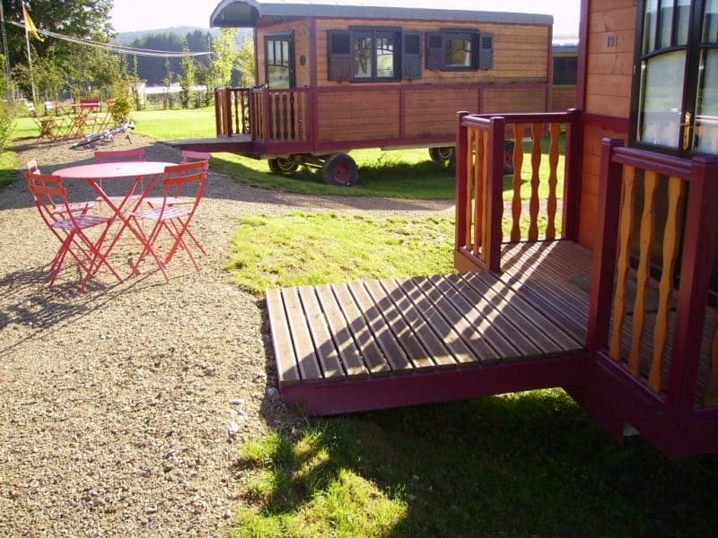 Charmante roulotte en Champagne-Ardenne, avec terrasse en bois et mobilier coloré.