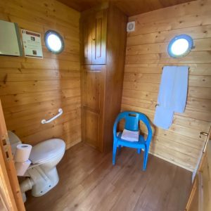 Toilettes en bois dans un hébergement insolite en Auvergne, ambiance chaleureuse.