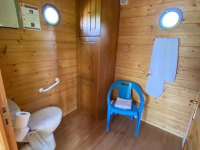 Toilettes en bois dans un hébergement insolite en Auvergne, ambiance chaleureuse.