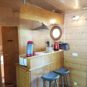 Hébergement insolite en bois à Champagne-Ardennes, avec un bar et des tabourets modernes.