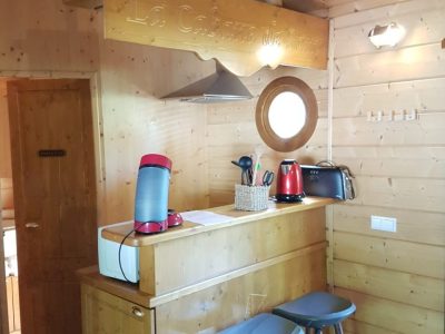 Hébergement insolite en bois à Champagne-Ardennes, avec un bar et des tabourets modernes.