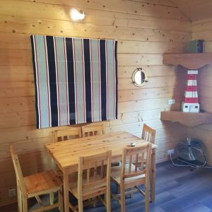 Hébergement insolite en bois à Champagne-Ardenne, avec une table en bois et décor marin.