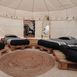 Tente de glamping à Champagne-Ardenne, avec lits en palettes et décoration moderne.