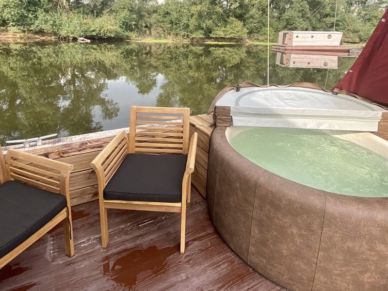 Hébergement insolite en Auvergne : cabane flottante avec jacuzzi et vue sur leau.