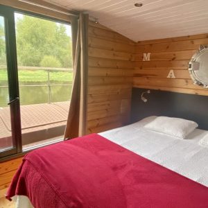 Chalet flottant en Auvergne, avec vue sur la rivière et intérieur en bois chaleureux.