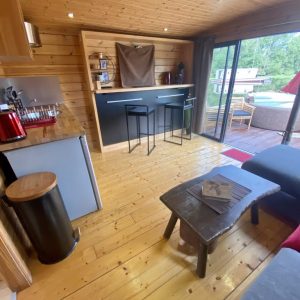 Hébergement insolite en Auvergne : chalet en bois avec cuisine ouverte et vue sur la nature.