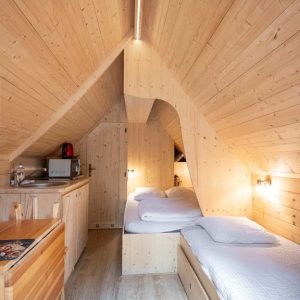 Chalet en bois à Champagne-Ardennes, intérieur chaleureux avec lit confortable.