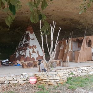 Hébergement insolite en Aquitaine : tipis et cabane sous une roche, ambiance naturelle.