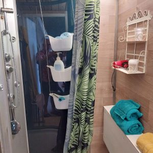 Douche moderne dans un hébergement insolite en Aquitaine, avec rideau tropical.