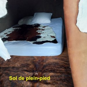 Hébergement insolite en Aquitaine : chambre avec lit sur sol de plein-pied en peaux.