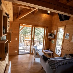 Cabane en bois en Bretagne, avec un intérieur chaleureux et une terrasse ensoleillée.
