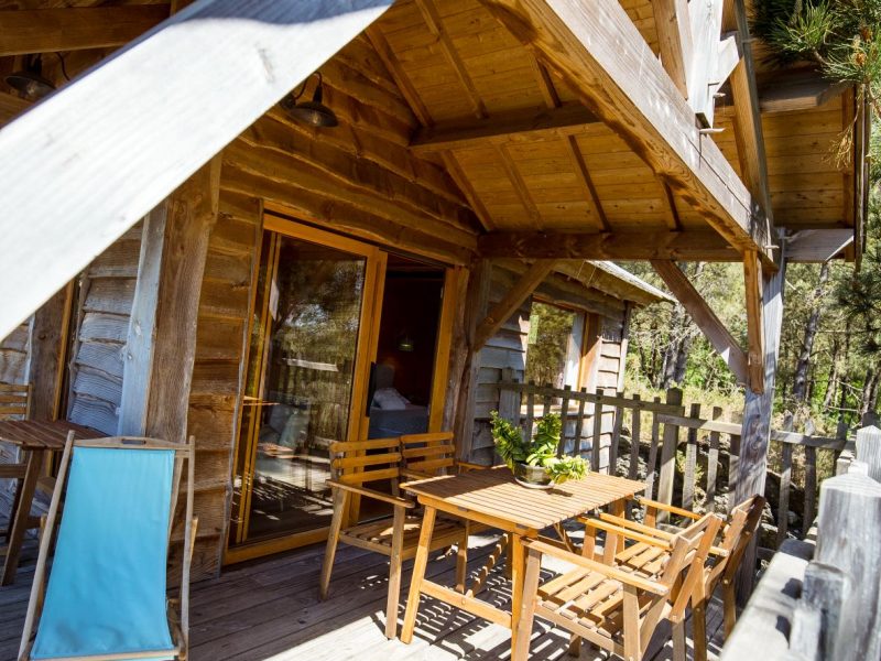 Cabane en bois en Bretagne avec terrasse en bois et vue sur la nature environnante.