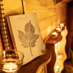 Hébergement insolite en Bretagne : intérieur chaleureux avec bougies et carnet décoré.