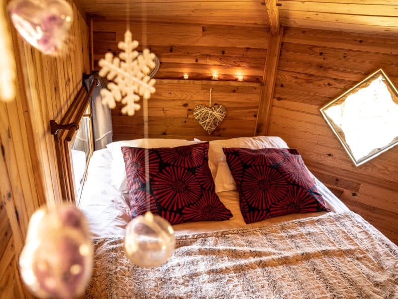Chalet en bois en Bretagne avec lit douillet et décor chaleureux.