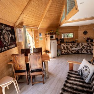 Cabane en bois en Bretagne, intérieur chaleureux avec meubles en bois et décor animalier.