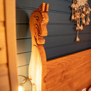 Hébergement insolite en Bretagne : lit en bois sculpté avec lampes chaleureuses.