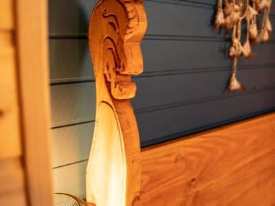 Hébergement insolite en Bretagne : lit en bois sculpté avec lampes chaleureuses.
