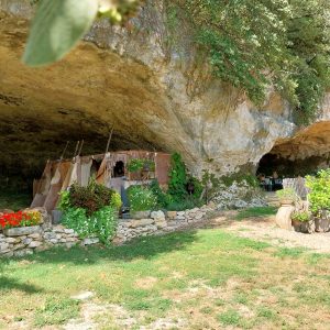 Hébergement insolite en Aquitaine : tipis colorés sous une falaise verdoyante.
