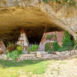 Tente amérindienne sous une grotte, entourée de fleurs et de verdure en Aquitaine.