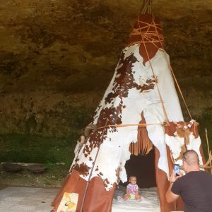 Tente tipie en Aquitaine, nichée sous une roche, idéale pour un séjour insolite.