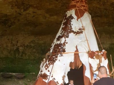 Tente tipie en Aquitaine, nichée sous une roche, idéale pour un séjour insolite.