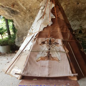 Tipi Auroch en Aquitaine, avec une structure en toile et bois sous une roche.