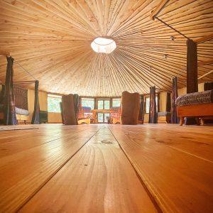 Intérieur dune yourte en Languedoc-Roussillon, avec un plafond en bois et des lits confortables.