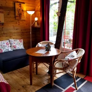 Cabane en bois à Languedoc-Roussillon, avec un coin salon chaleureux et des coussins colorés.