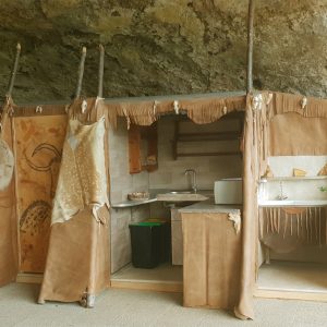 Hébergement insolite en Aquitaine : cabane en cuir sous une roche, décor naturel.