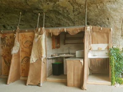 Hébergement insolite en Aquitaine : cabane en cuir sous une roche, décor naturel.