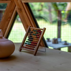 Hébergement insolite en Auvergne-Rhône-Alpes, avec un abaque coloré et une théière en terre cuite.