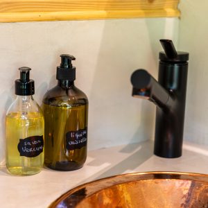 Élégant hébergement insolite en Auvergne-Rhône-Alpes avec lavabo en cuivre et produits naturels.