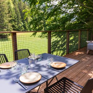 Hébergement insolite en Auvergne-Rhône-Alpes avec terrasse en bois et vue sur la nature.