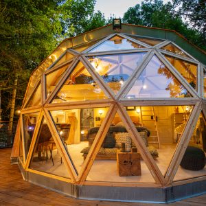 Dôme géodésique lumineux en pleine nature, offrant un séjour unique en Auvergne-Rhône-Alpes.