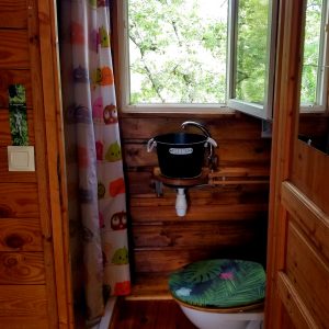 Toilette en bois dans un hébergement insolite en Languedoc-Roussillon, vue sur la nature.