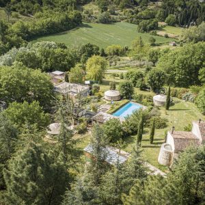 Hébergement insolite en Languedoc-Roussillon, avec des cabanes et une piscine entourée de verdure.