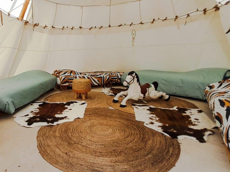 Tipi cosy à Champagne-Ardenne, avec lits colorés et décoration bohème.