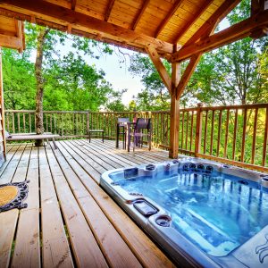 Cabane perchée en Midi-Pyrénées avec jacuzzi sur la terrasse en bois.