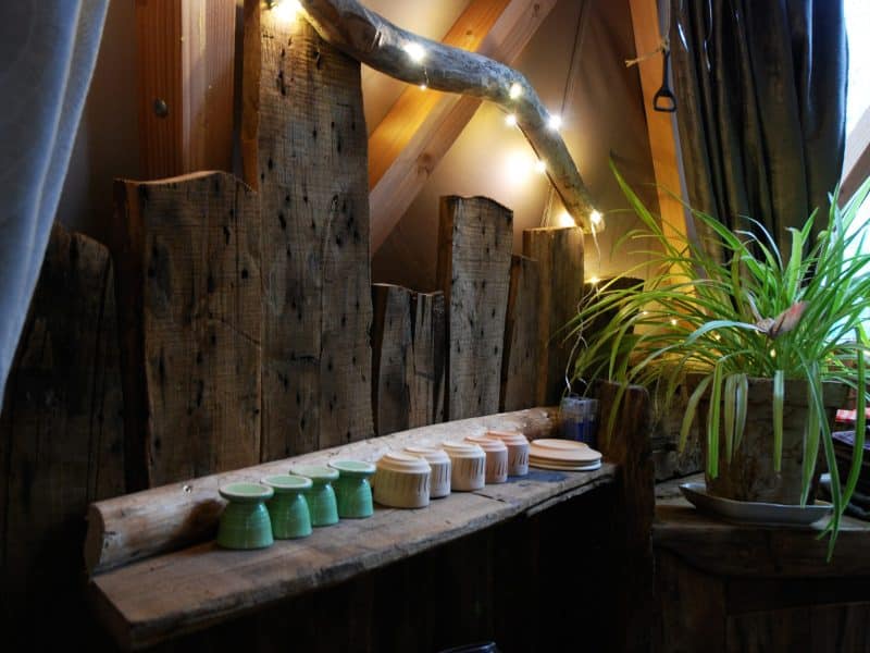 Hébergement insolite en Limousin, intérieur en bois avec pots colorés et plantes.