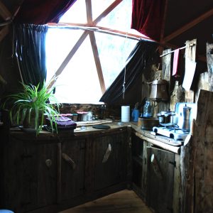 Dôme en bois au Limousin, intérieur chaleureux avec cuisine rustique et lumière naturelle.