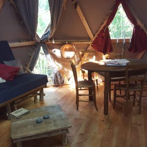 Hébergement insolite en yourte à Limousin, intérieur chaleureux avec bois et lumière naturelle.
